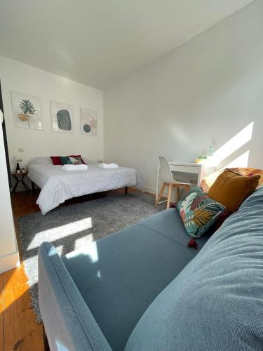 a room with a couch and a bed and a desk at Centro da Vila in Ponte de Lima