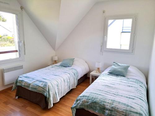 two beds in a room with two windows at Lann Vras - Maison proche littoral - K25 in Locmariaquer