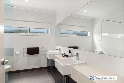 een witte badkamer met 2 wastafels en een spiegel bij 330 Church Street, Cowes in Cowes