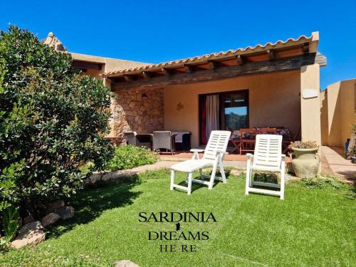 two chairs sitting in the yard of a house at Villetta Flora with pool and private parking in Costa Paradiso