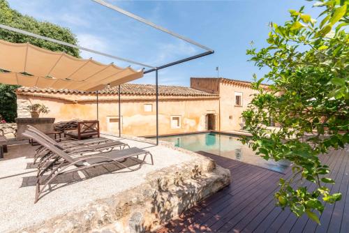 um pátio com uma piscina, cadeiras e um guarda-sol em Sa Pobla 21842 Mallorca6 em Sa Pobla