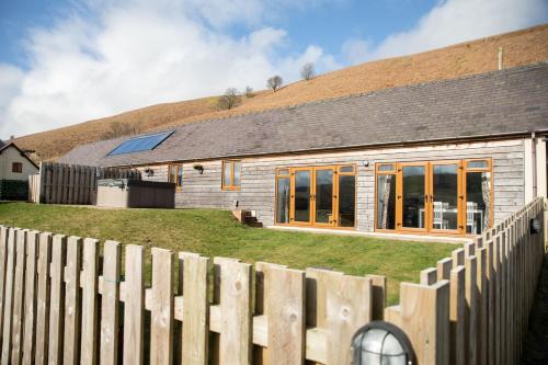 a house with a wooden fence in front of it at 2 Beacon View Barn in Felindre