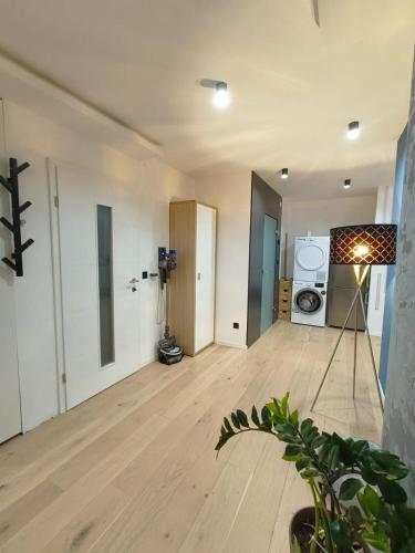 an empty living room with a wooden floor and a washing machine at KELEIA NEW VILLAGE in Celje