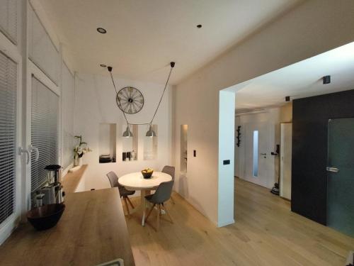 a dining room with a table and a clock on the wall at KELEIA NEW VILLAGE in Celje