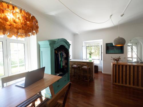 a living room with a table with a laptop on it at Impact Beach House in Estoril