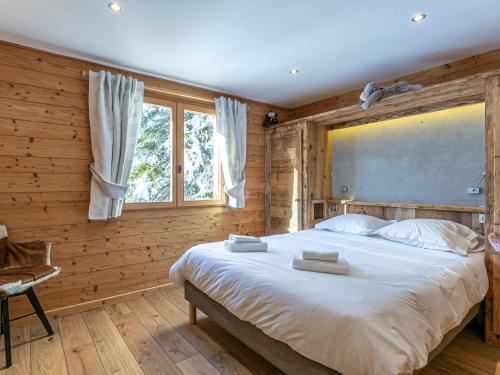 - une chambre avec un grand lit dans un mur en bois dans l'établissement Chalet 4 Étoiles 13 Pers. à La Clusaz - Grande Terrasse, Garage, WIFI, Arrêt Skibus à Proximité - FR-1-437-81, à La Clusaz