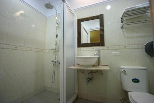 a bathroom with a sink and a toilet and a mirror at A Cup Hostel in Kenting