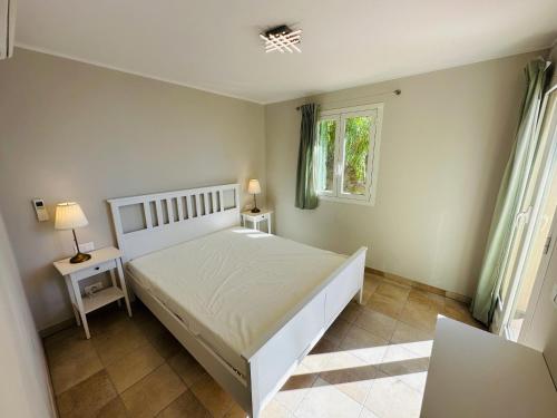 een slaapkamer met een wit bed en een raam bij Maison Vue Mer Eze sur Mer in Èze