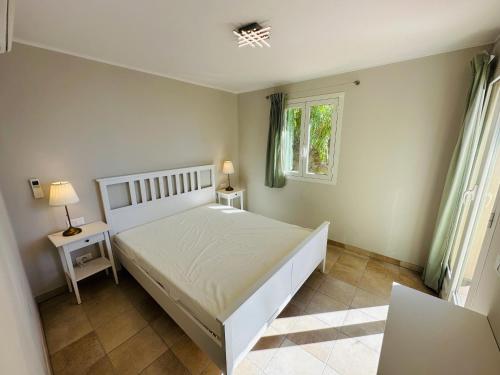 1 dormitorio con cama blanca y ventana en Maison Vue Mer Eze sur Mer, en Èze