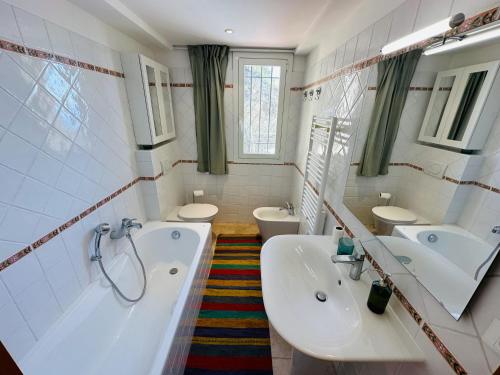 La salle de bains est pourvue de 2 lavabos, d'une baignoire et de 2 toilettes. dans l'établissement Maison Vue Mer Eze sur Mer, à Èze