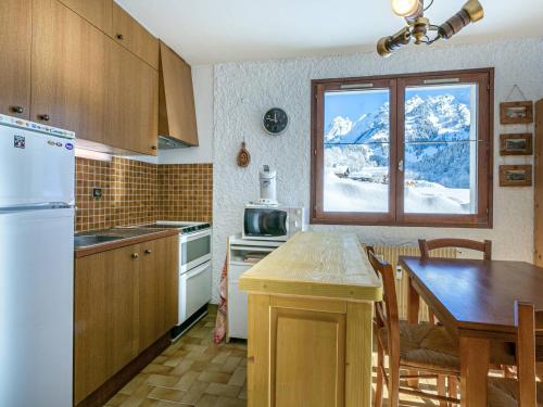 une cuisine avec une table et une fenêtre avec de la neige dans l'établissement Appartement plein Sud avec garage à La Clusaz - FR-1-437-83, à La Clusaz