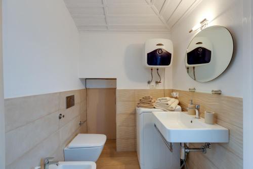 a bathroom with a sink and a toilet and a mirror at Palazzo storico del 1600 in Bosa