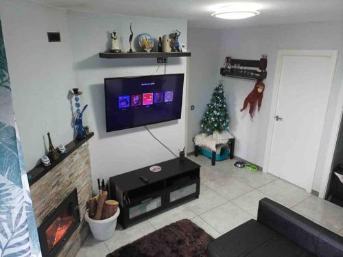 a living room with a christmas tree and a television at Precioso piso en la playa de Madrid a 45 min del centro de la ciudad in Madrid