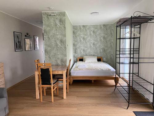 - une chambre avec un lit, une table et des chaises dans l'établissement Helles Appartement mit Terrasse, à Friedrichshafen