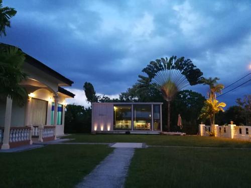 una casa con una palmera en el patio en My Excel Garden Mini Glass Villa with Forest View, en Air Hangat