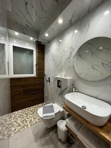 a bathroom with a white sink and a toilet at CARA Creta Home in Kolymvari