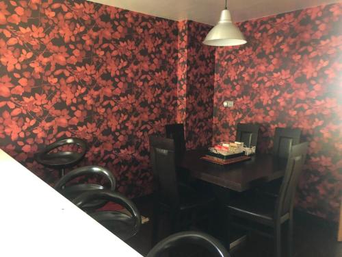 a dining room with a table and red floral wallpaper at A de Bego in Mougás