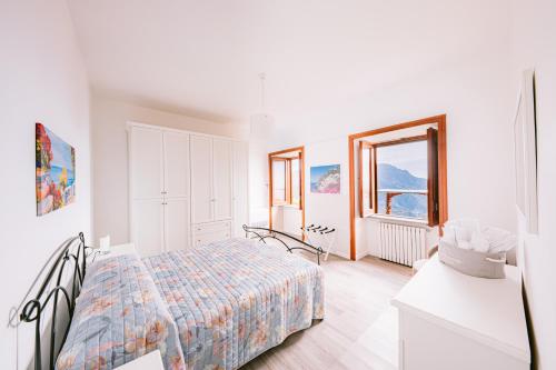 a white bedroom with a bed and a window at Appartamento Anna in Villa Laura in Scala