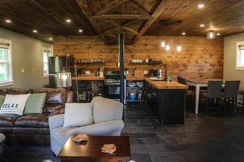 Modern Industrial Farmhouse - The Wayback في Orange: غرفة معيشة مع أريكة ومطبخ وطاولة