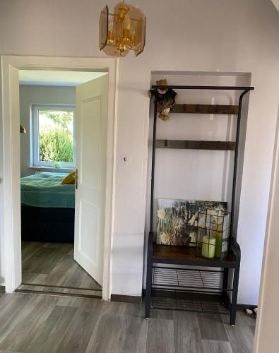 a hallway with a mirror and a room with a bed at Das Krimihaus Ostfriesland in Rhauderfehn