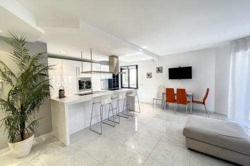 Il dispose d'une cuisine et d'un salon avec des chaises orange et un canapé. dans l'établissement Cannes Rue d'Antibes Premium 2 BDR 2 baths Exclusive Olam Properties, à Cannes
