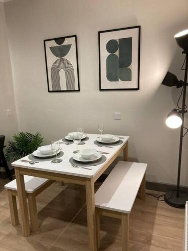 a wooden table with plates and wine glasses on it at Stunning Coastal Retreat in Carrickfergus