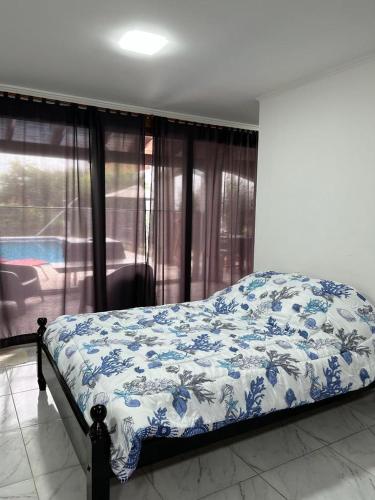 a bedroom with a bed with a blue and white blanket at El Descanso Casa de retiro in Tandil
