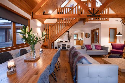 a living room with a large wooden table and chairs at The Wilds - Seasgair Lodges in Kingussie