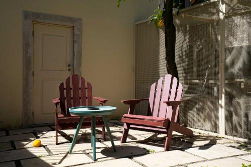 two chairs and a table in a patio at Entre Ruas Apartments in Coimbra