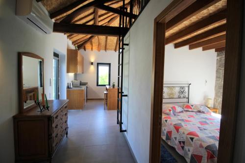 um quarto com uma cama e um corredor com uma cozinha em Casas do Campo da Moita em Baião