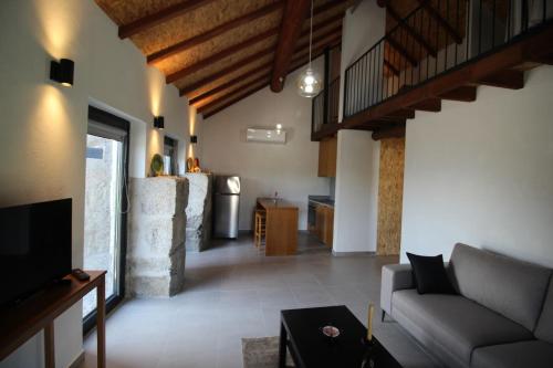 a living room with a couch and a tv at Casas do Campo da Moita in Baião