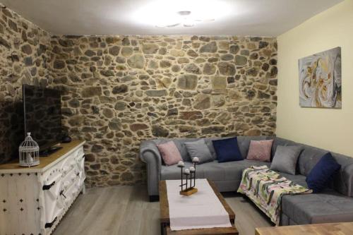 a living room with a couch and a stone wall at www luabierzo in Molinaseca