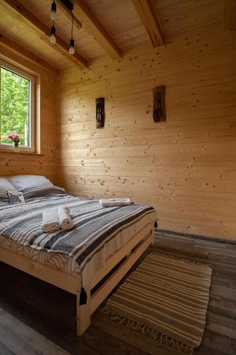 a bedroom with a bed in a log cabin at Groszkówka in Narewka