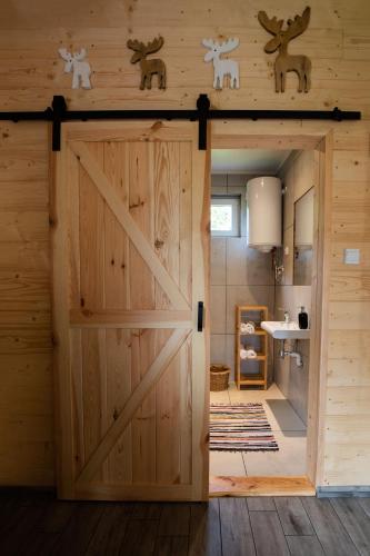 an open barn door in a room with wooden walls at Groszkówka in Narewka