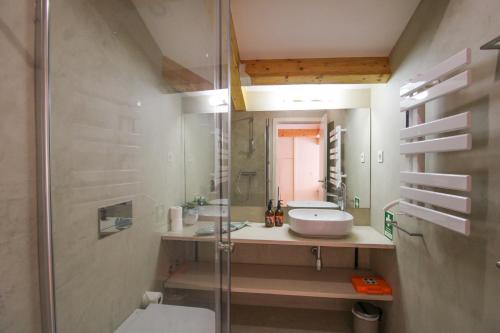 a bathroom with a sink and a glass shower at Porto Unique Cosy Duplex in Porto