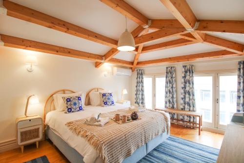 una camera con un grande letto in una stanza con soffitti in legno di Porto Unique Cosy Duplex a Porto