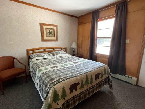a bedroom with a bed and a window at Hillcrest Inn & Motel in Rapid River