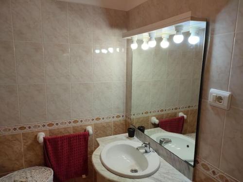 ein Badezimmer mit einem Waschbecken und einem großen Spiegel in der Unterkunft Piso centrico en Ribadeo in Ribadeo
