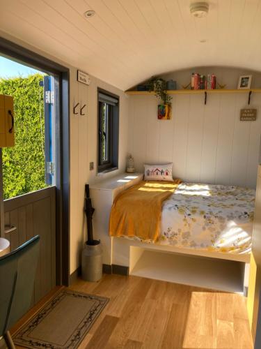 a bedroom with a bed in a small room at Atlantic Way Shepherd Hut in Moville