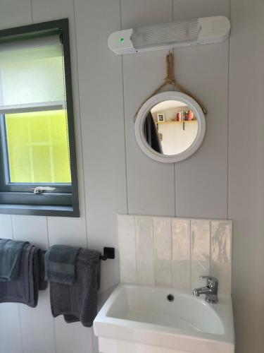 a bathroom with a sink and a mirror at Atlantic Way Shepherd Hut in Moville