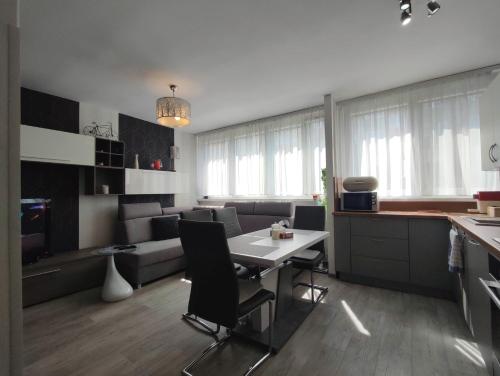 a kitchen and living room with a table and chairs at Komfortowy Apartament w Kłodzku in Kłodzko