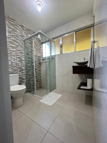 a bathroom with a shower and a toilet and a sink at Pousada da Praia in Paraty