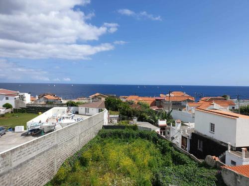 uitzicht op een stad met gebouwen en de oceaan bij Farol Guesthouse in Angra do Heroísmo