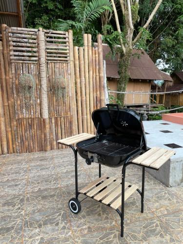 a grill sitting on a bench next to a fence at Bamboo Hideaway, Bungalows with Pool and Kitchen in Ko Mak