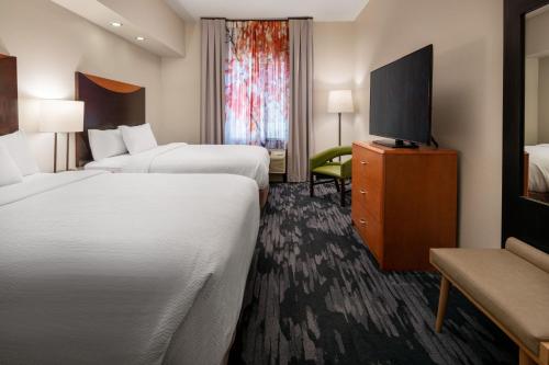 a hotel room with two beds and a flat screen tv at Fairfield Inn & Suites by Marriott Visalia Tulare in Tulare