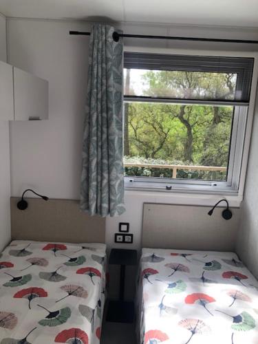 ein kleines Schlafzimmer mit einem Bett und einem Fenster in der Unterkunft Camping de Parpaillon in Roquebrune-sur-Argens