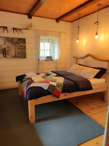 a bedroom with a wooden bed with a quilt on it at Gniazdo w Felicjanowie in Uniejow