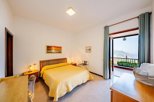 - une chambre avec un lit jaune et un balcon dans l'établissement Appartamento Emma in Villa Laura, à Scala