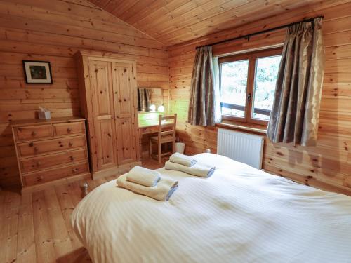 a bedroom with a bed in a log cabin at Kingfisher Lodge in Market Rasen