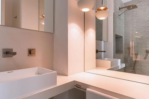 ein weißes Badezimmer mit 2 Waschbecken und einem Spiegel in der Unterkunft Upscale Rotschild by Five Stay in Tel Aviv